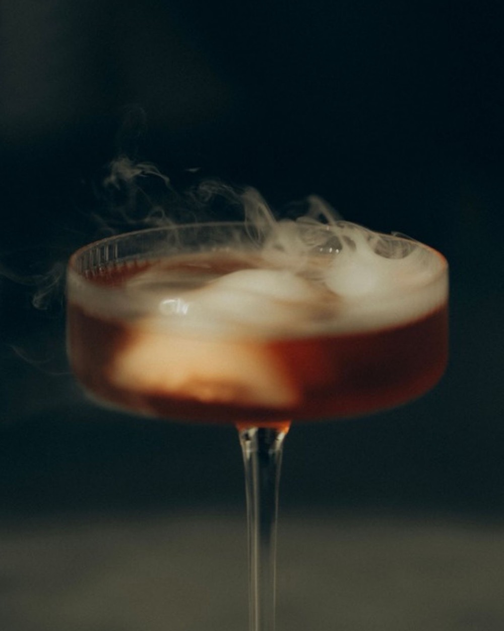 Coctel con humo en una copa de cristal